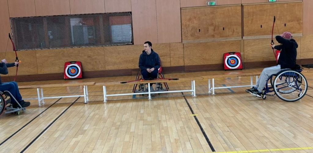 Passe D handi sport : Photo de personnes en fauteuil roulant jouant à l'arc